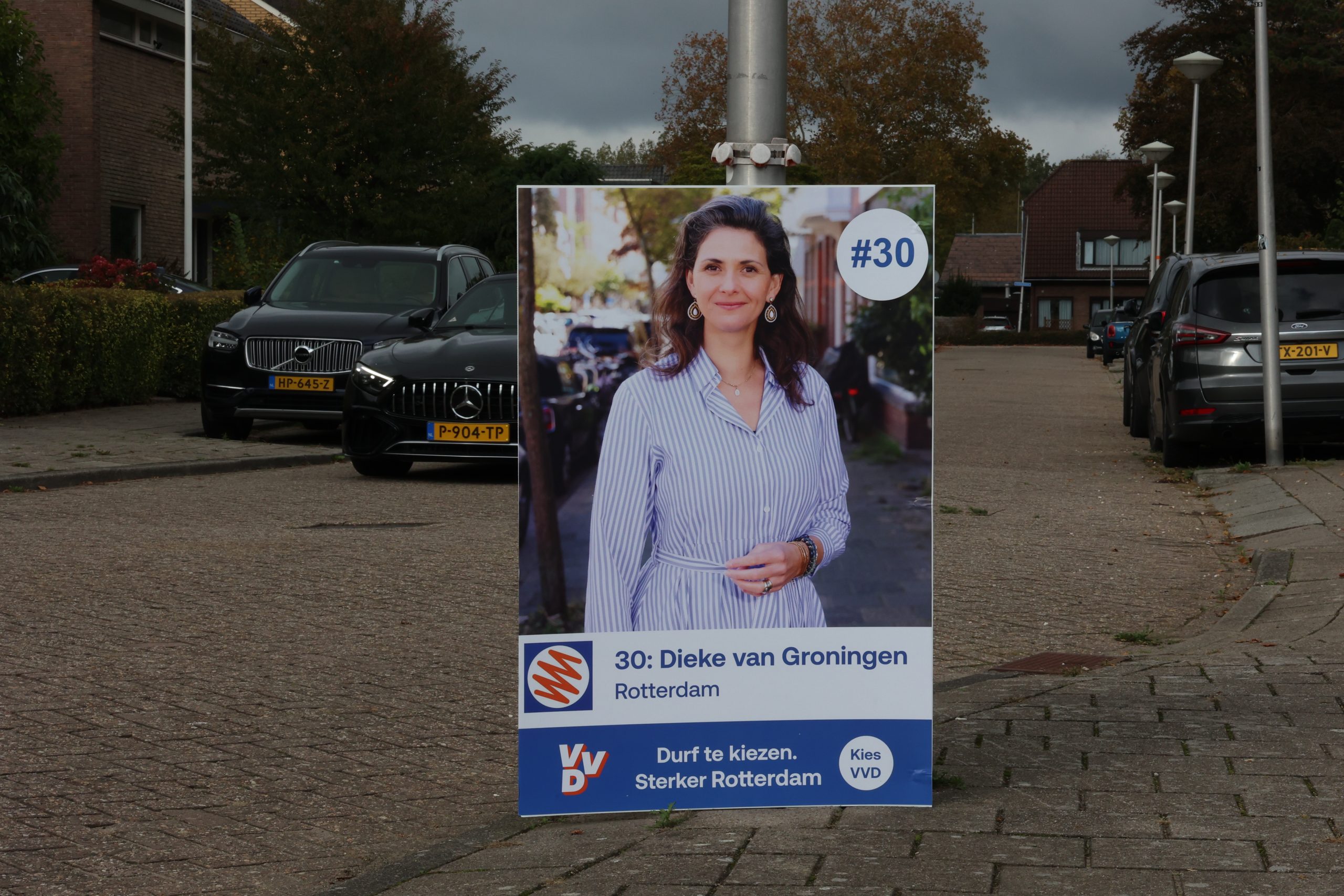 Sandwichbord langs de weg met een campagneposter